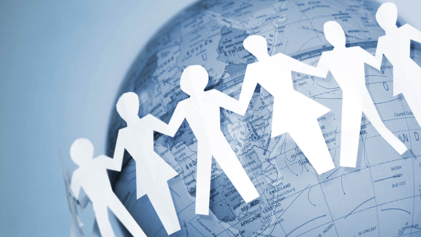 A row of paper cutout people holding hands is draped across a globe, symbolizing global unity and cooperation in MPS advocacy and support. The globe shows continents and countries in soft blue tones.